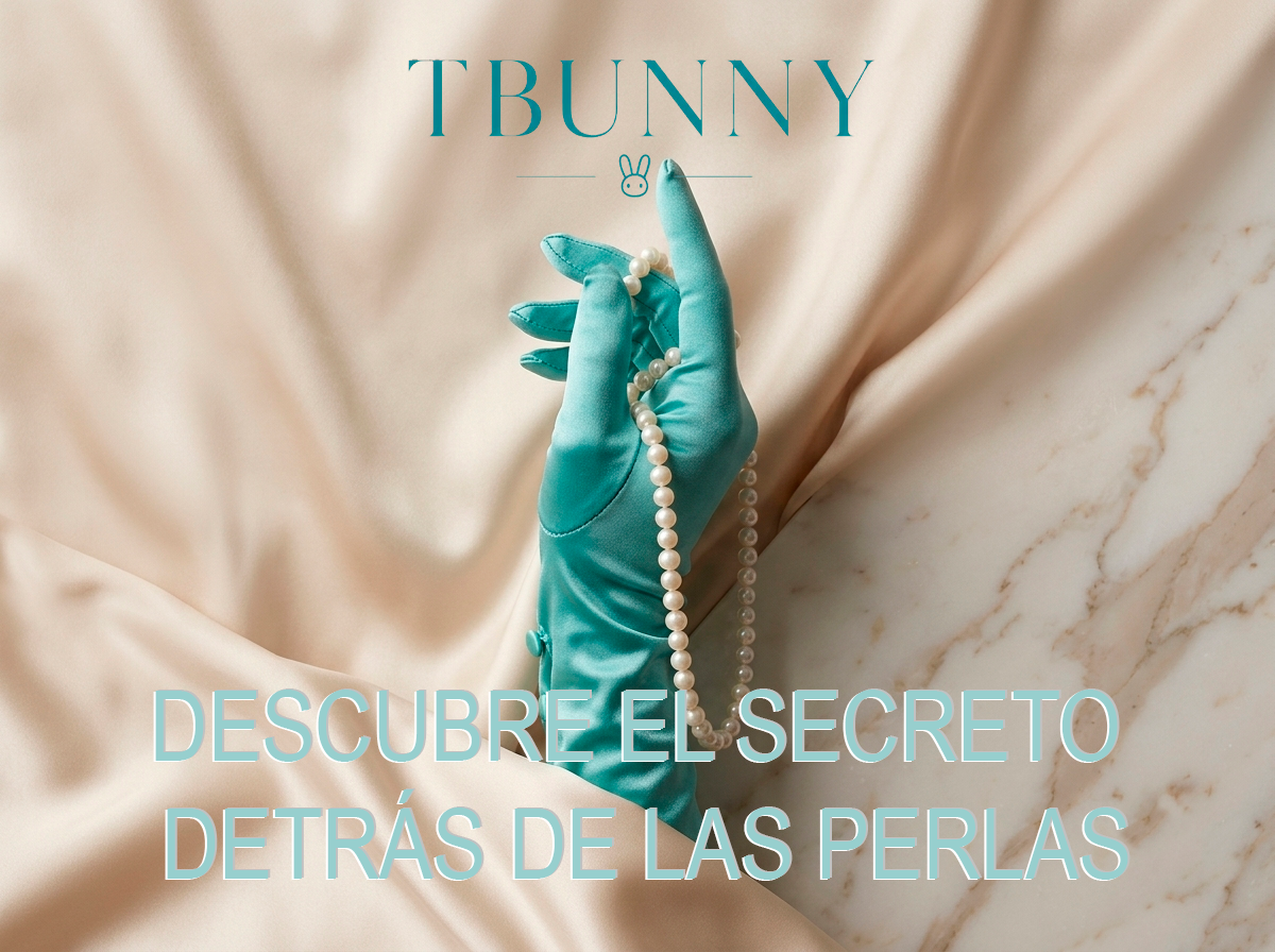 Primer teaser visual: Una mano con guante de satén turquesa sostiene delicadamente un hilo de perlas sobre un fondo de seda champagne y mármol, anunciando el nuevo ritual de bienestar íntimo TBUNNY.