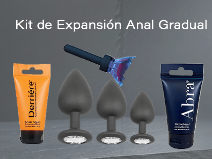 Kit de expansión anal gradual con tres plugs de silicona negros sobre fondo de piedra y metal, acompañados de lubricantes Abra y Derrière.
