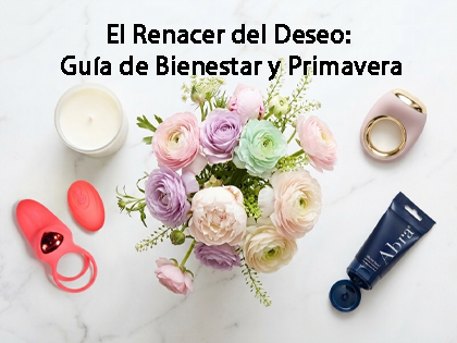 Vista cenital estilo flat lay sobre mármol blanco que muestra el anillo vibrador Lick Ring rojo con su control, el lubricante Abra azul con la marca visible, una vela blanca y un ramo central de flores primaverales en tonos pastel.
